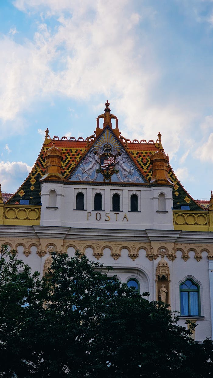 An ornate historical postal building in Pécs, Hungary, with Zsolnay tiles and architectural details.